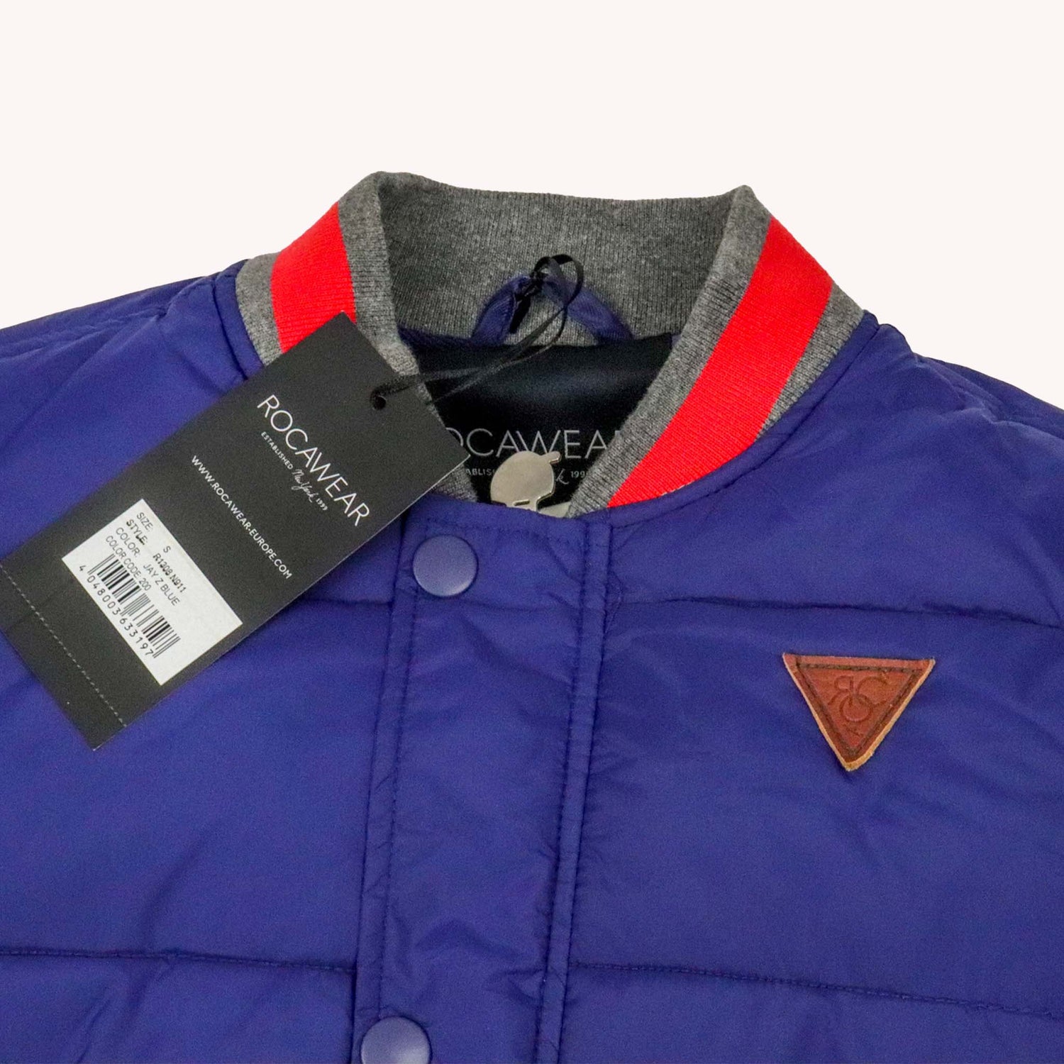 Blue jacket with red and gray collar, Rocawear tag, and logo on a white background