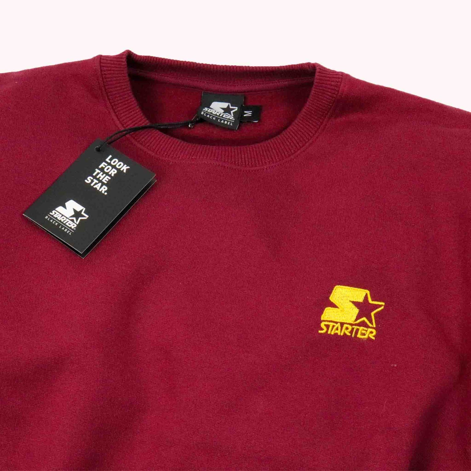 Maroon sweatshirt with yellow Starter logo and tag on a white background