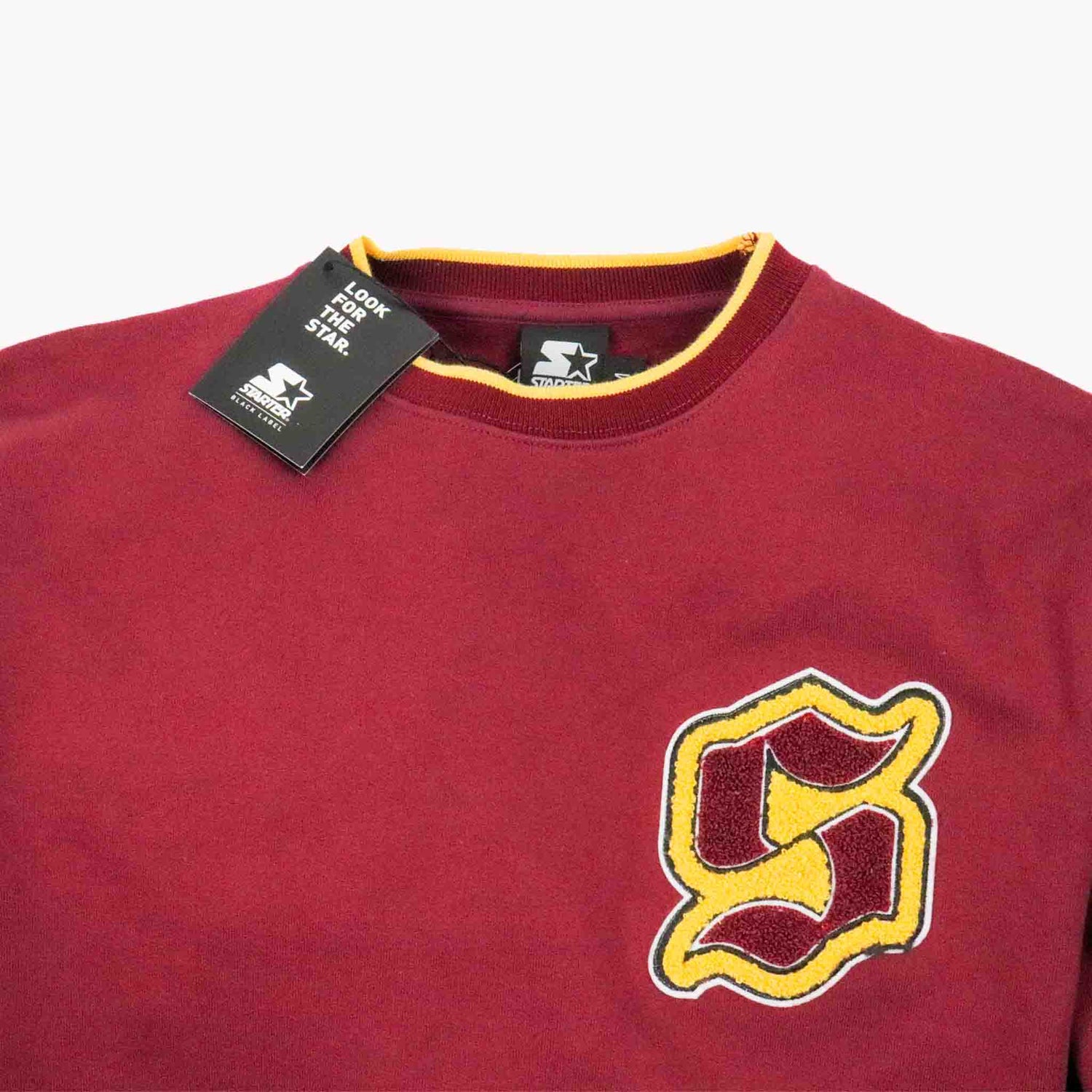 Maroon sweatshirt with yellow logo and tag on a white background