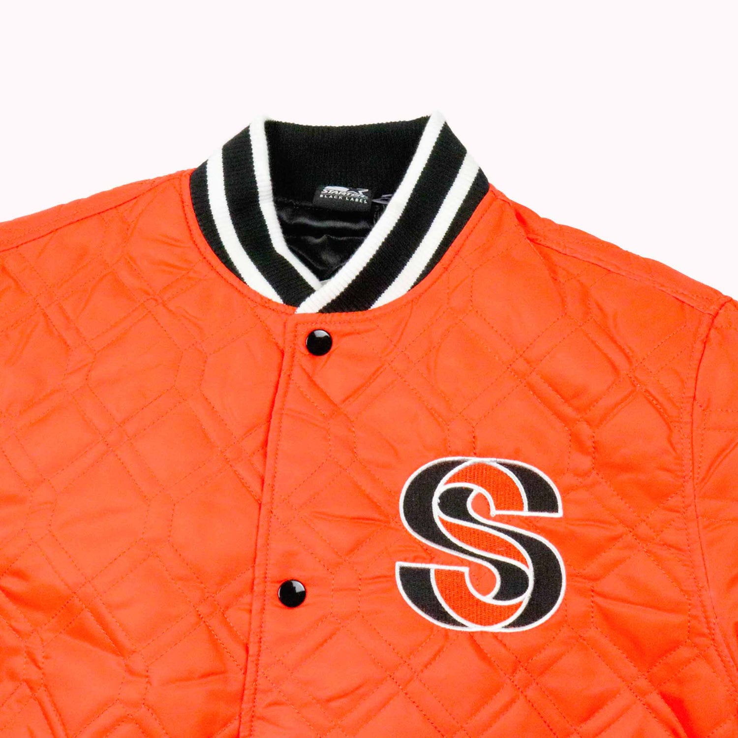 Orange quilted jacket with a black 'S' logo on a white background