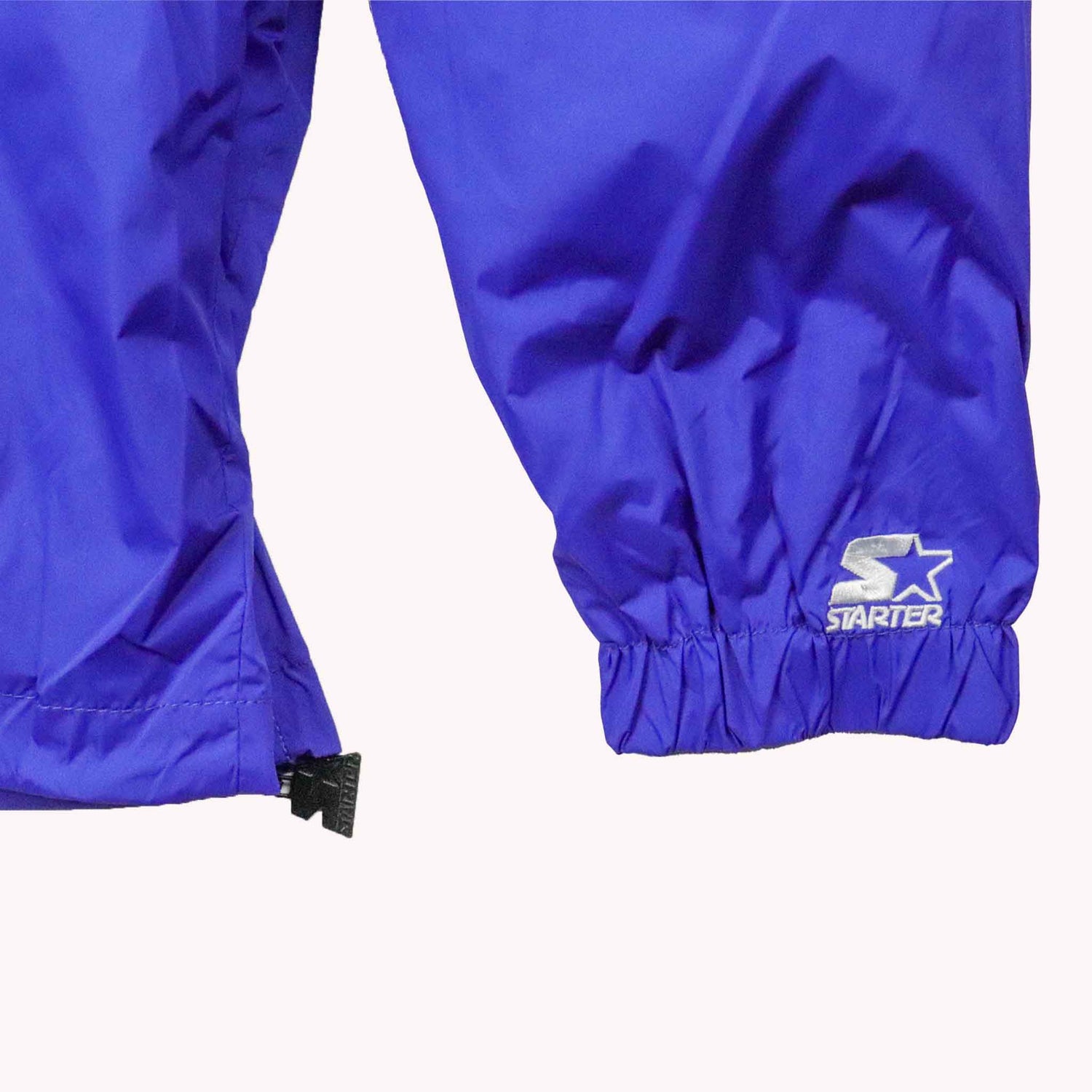 Blue rain pants with Starter logo on a white background