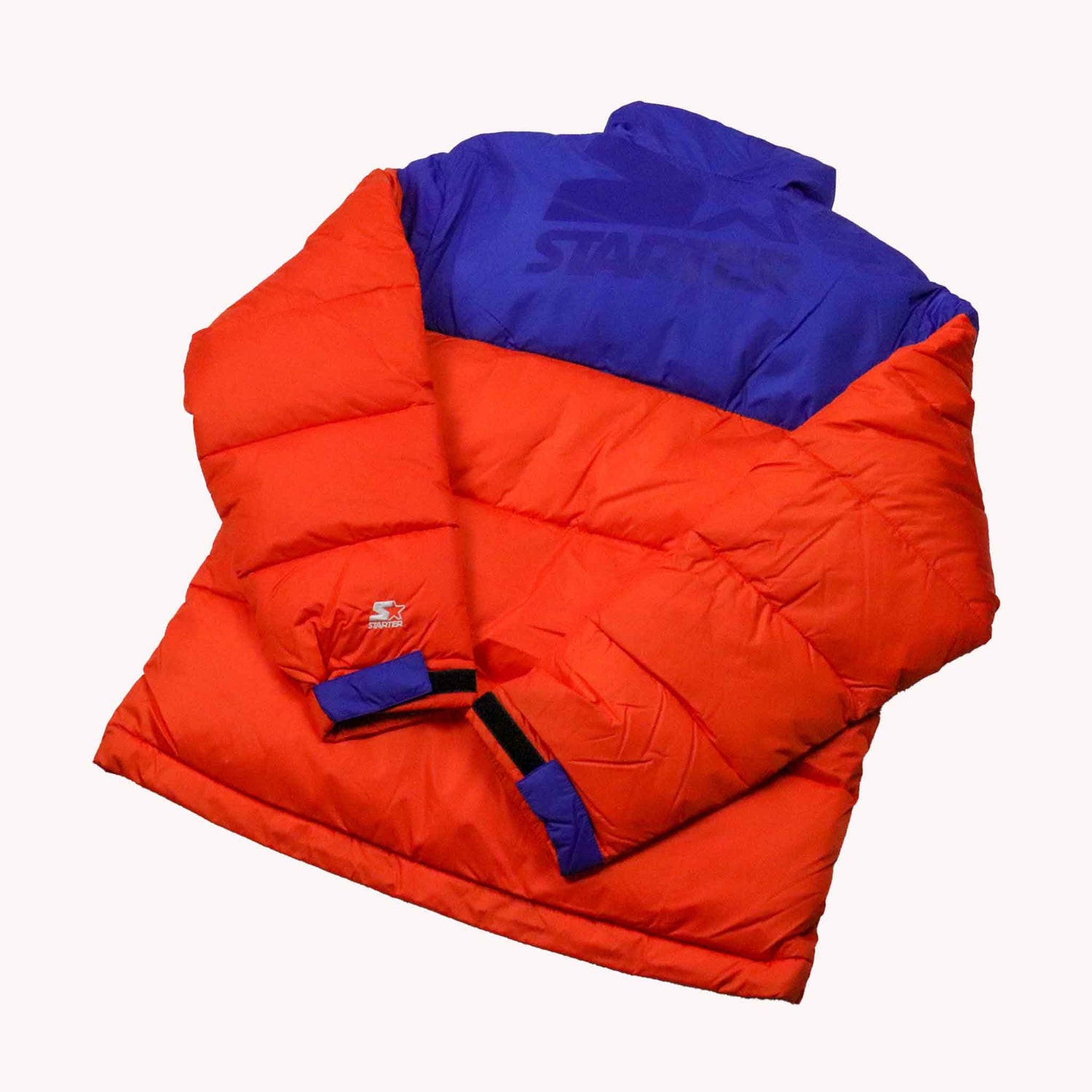 Orange and blue puffer jacket on a white background