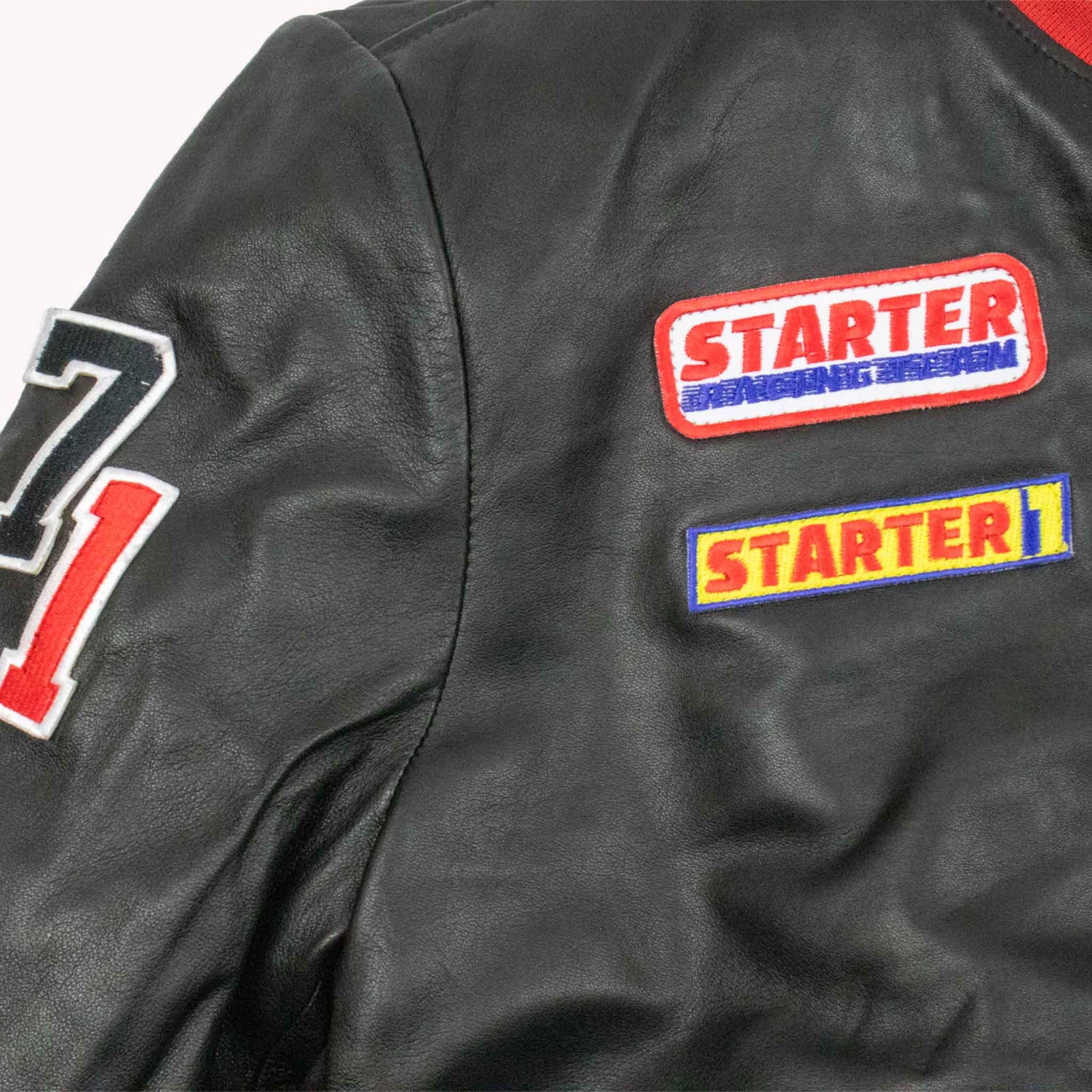 Black jacket with 'Starter' patches on a gray background
