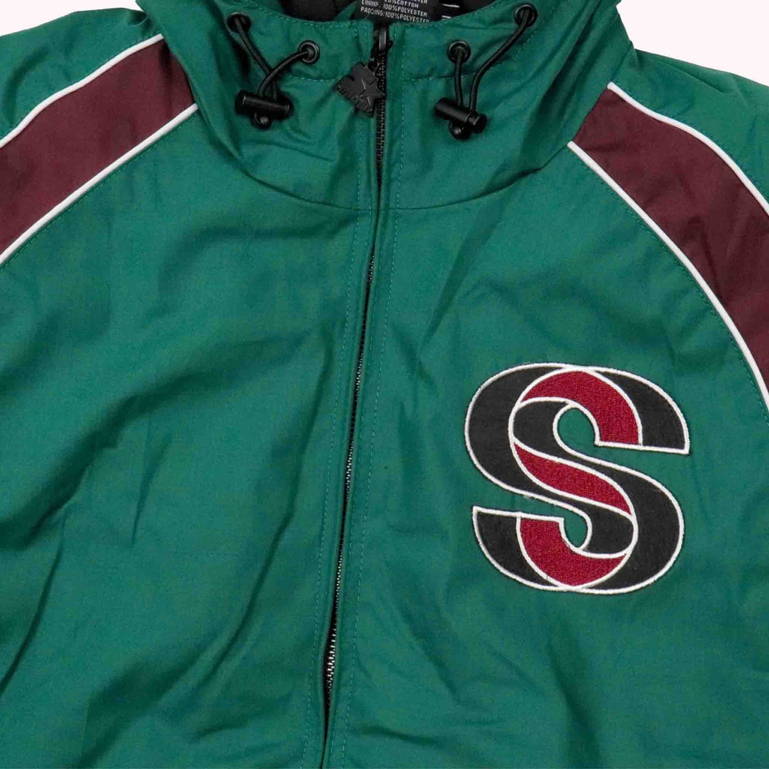 Green jacket with a red and black logo on a white background