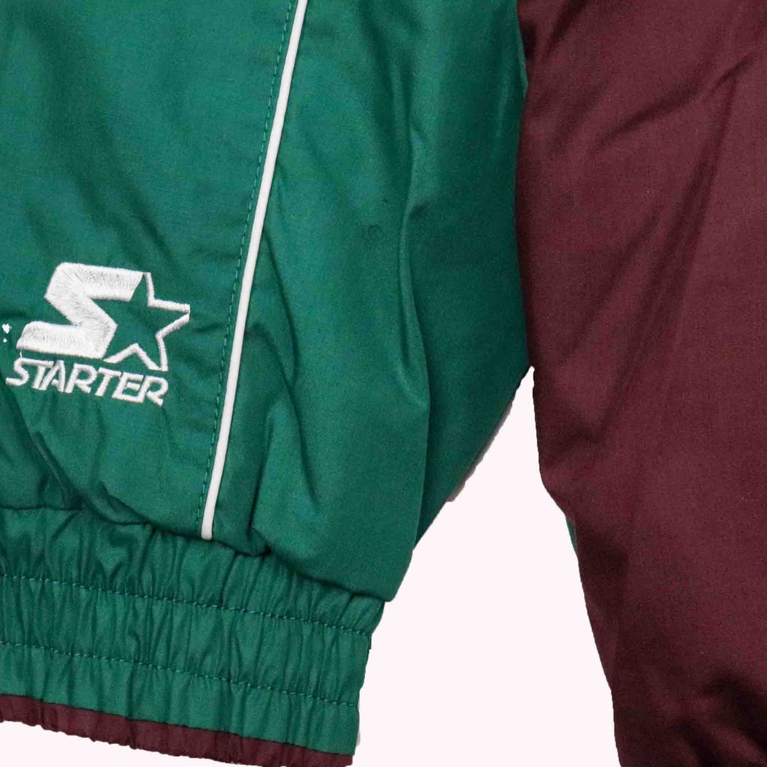 Green jacket with Starter logo next to a maroon jacket on a white background