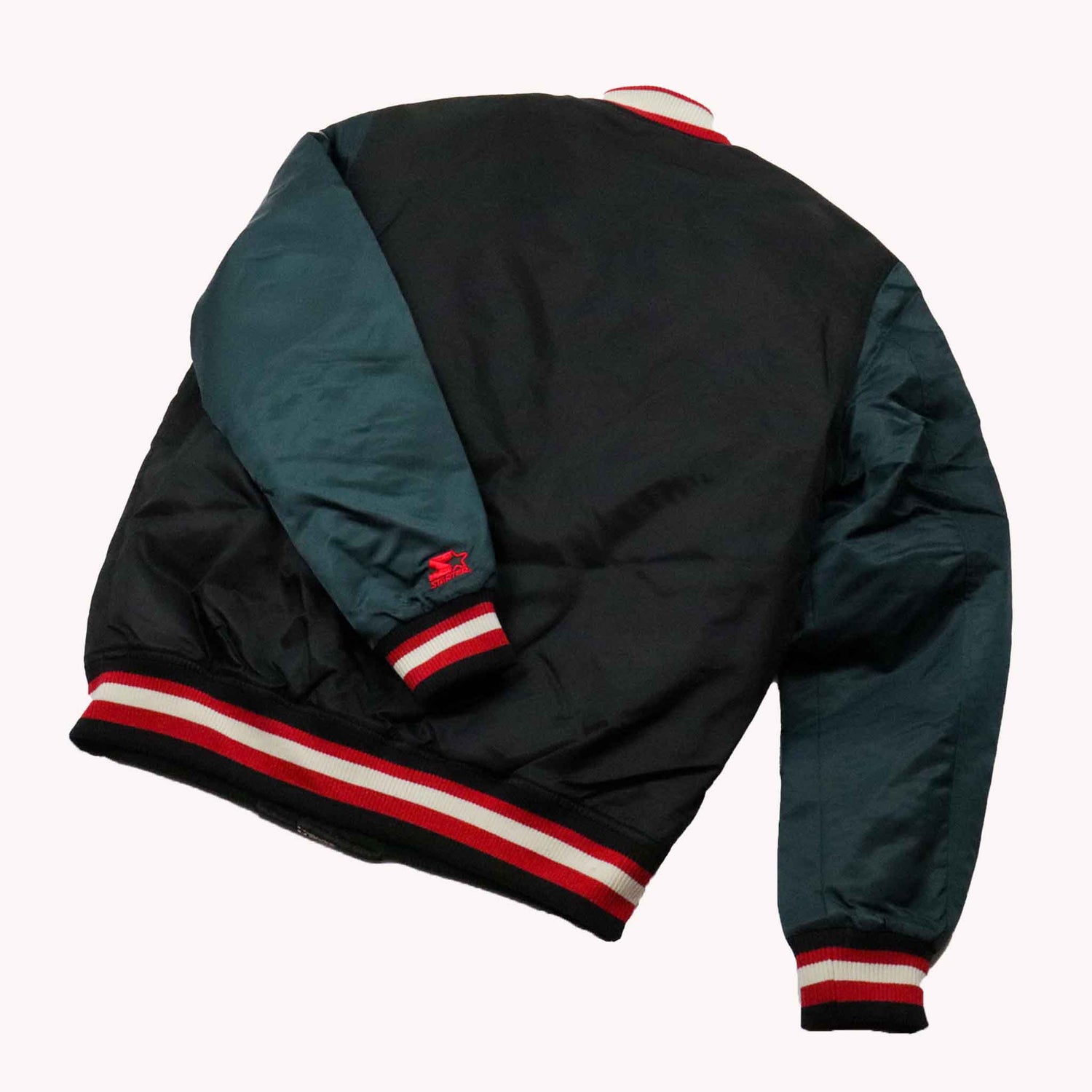 Black and green jacket with red and white accents on a white background