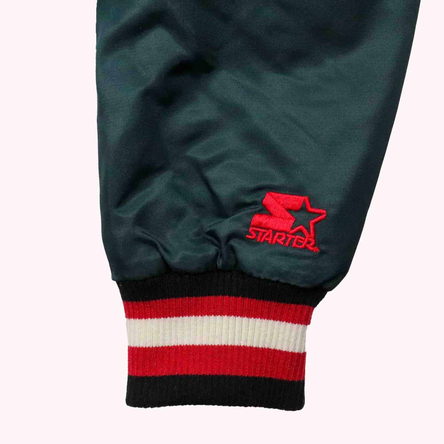 Green sweatshirt with red and white striped cuff and Starter logo on a white background
