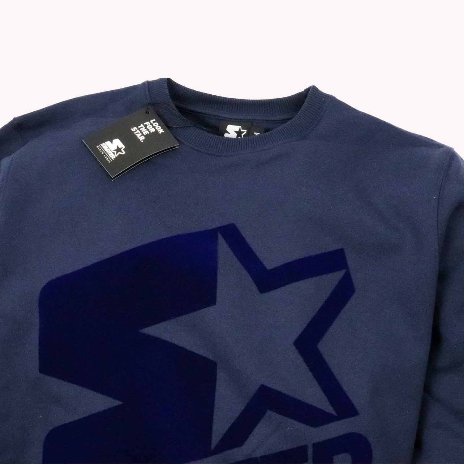 Navy blue sweatshirt with a large star logo and a tag on a white background