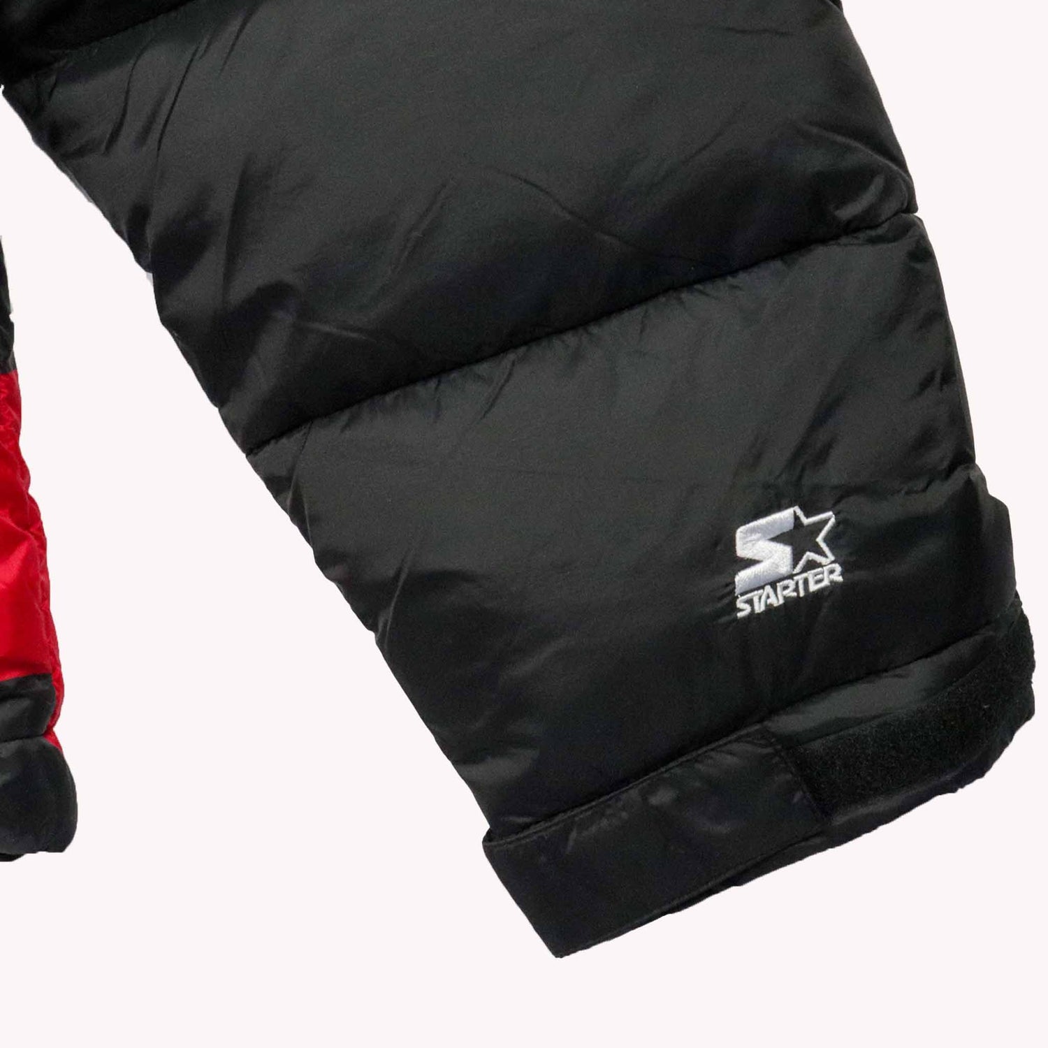 Black puffer jacket with Starter logo on a white background