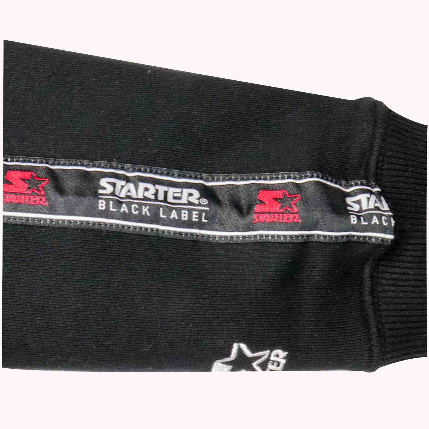 Close-up of a black label with 'Starter' branding on a black background